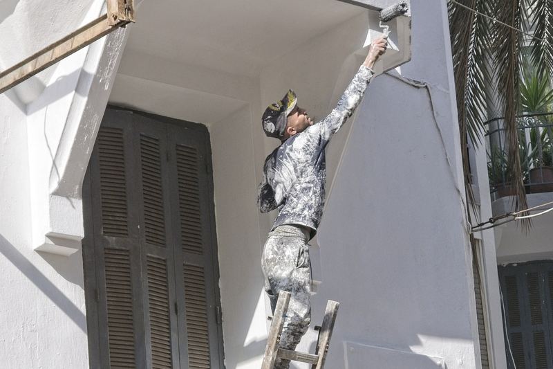 Painter working high on a building facade